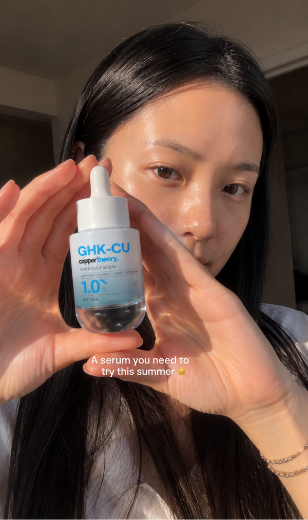 Customer holding CopperTheory GHK-Cu copper peptide hair serum for scalp and hair care routine